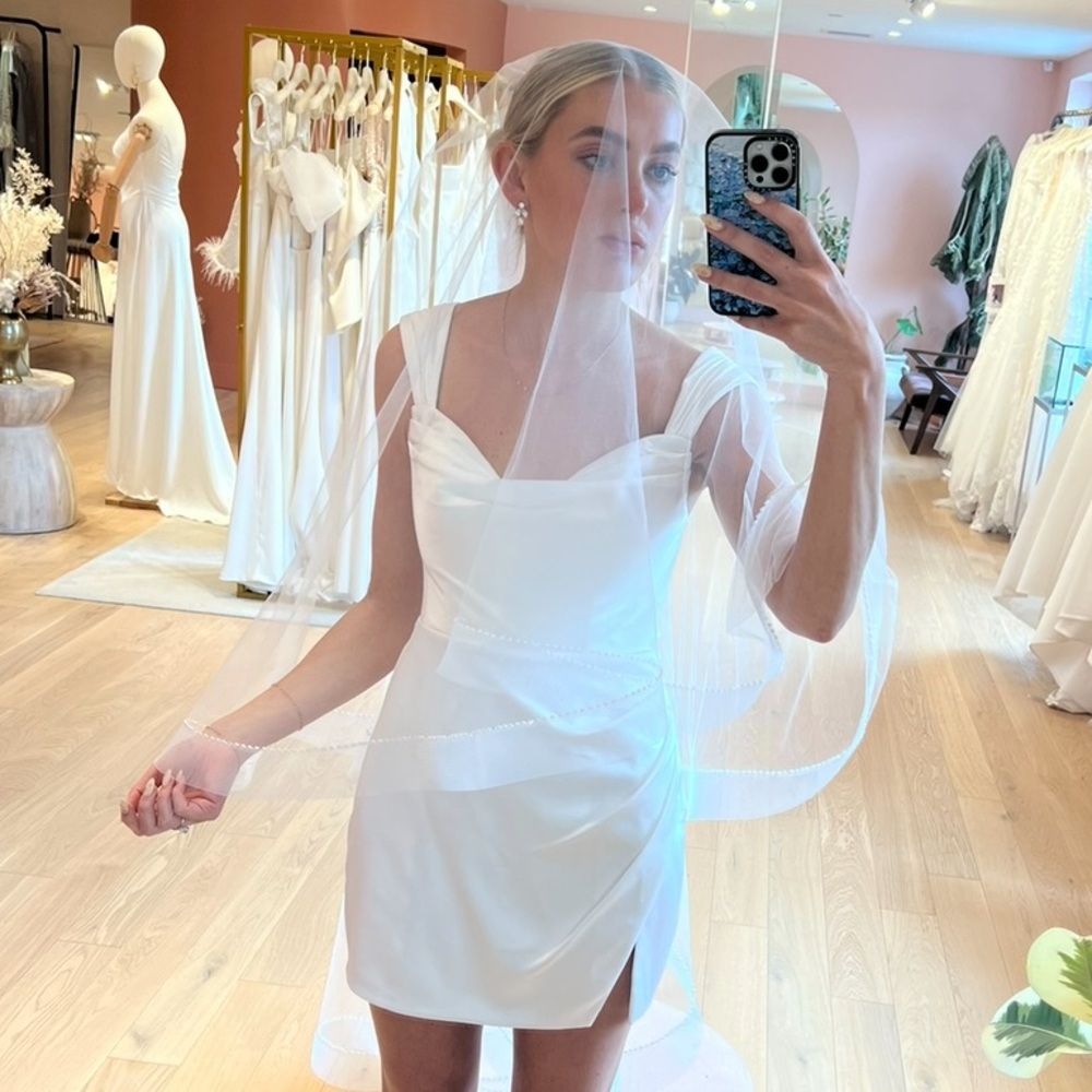 Brand new, never worn, fingertip veil with detailed hem and blusher